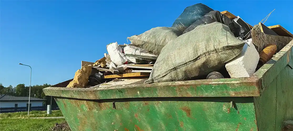 Green metal skip full of rubbish